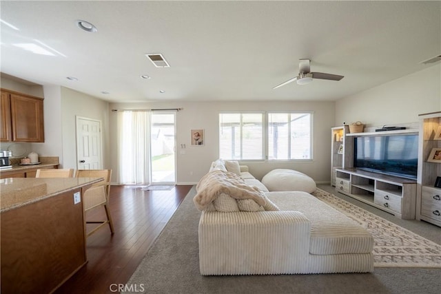 living area featuring a wealth of natural light, wood finished floors, and visible vents