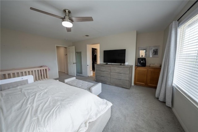 bedroom featuring baseboards, visible vents, a ceiling fan, and light colored carpet