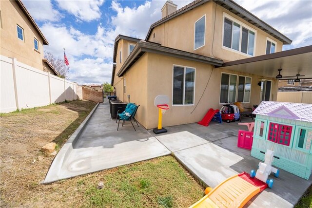 back of house with a fenced backyard, a ceiling fan, a patio, and stucco siding