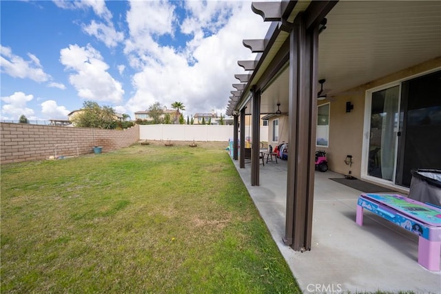 view of yard with a ceiling fan, a fenced backyard, and a patio