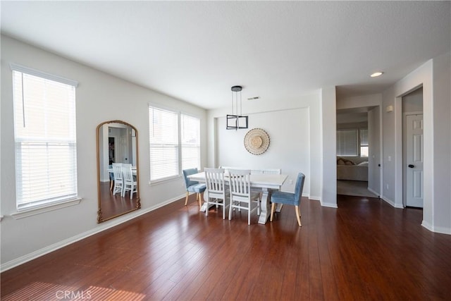 dining area featuring visible vents, baseboards, and wood finished floors