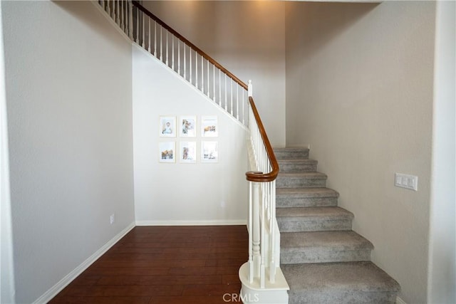 stairway with wood-type flooring and baseboards