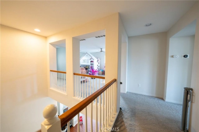 corridor featuring visible vents, carpet, an upstairs landing, and baseboards