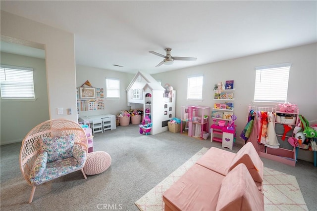 game room with a healthy amount of sunlight, ceiling fan, and carpet flooring