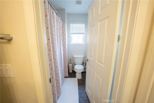 bathroom featuring toilet, visible vents, and tile patterned floors