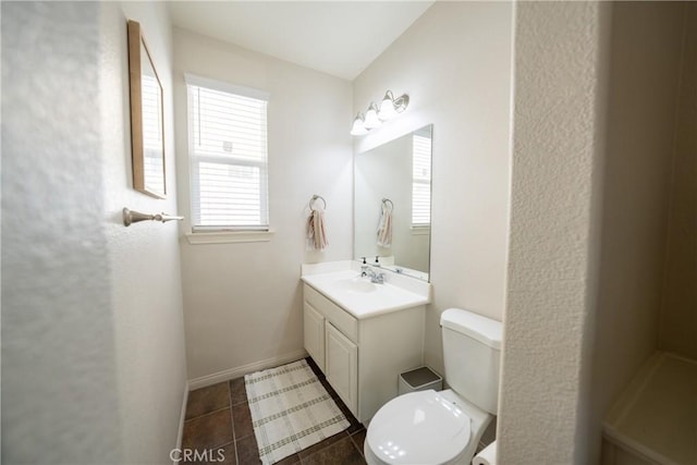 bathroom with tile patterned flooring, vanity, toilet, and baseboards