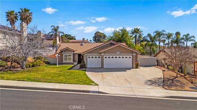 view of front of home with fence, driveway, a front lawn, a garage, and a tile roof