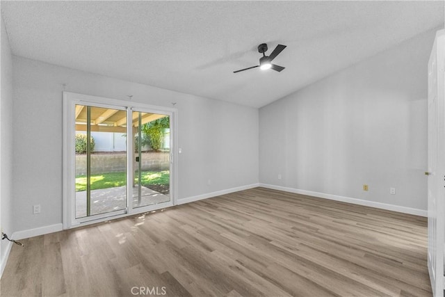 empty room with a textured ceiling, baseboards, ceiling fan, and wood finished floors