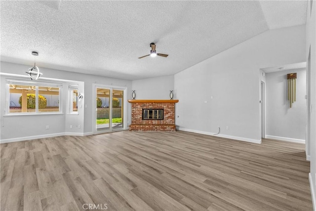 unfurnished living room with ceiling fan, baseboards, wood finished floors, and a fireplace