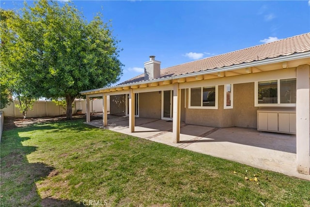 rear view of house with a patio, a yard, fence private yard, and stucco siding