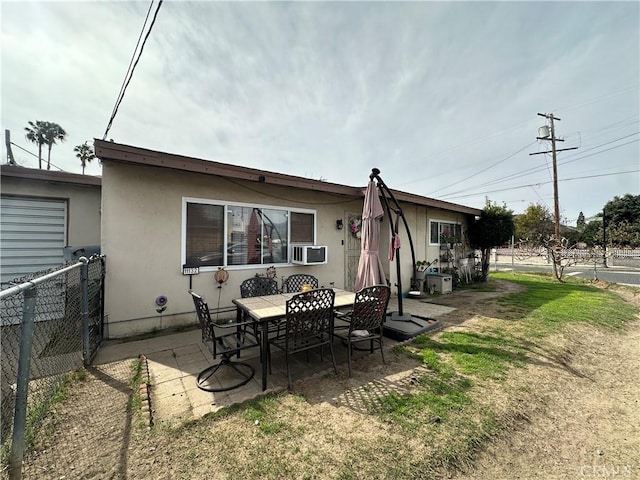 back of house featuring a patio area, outdoor dining space, cooling unit, and fence