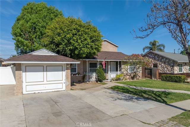 ranch-style house with stucco siding, covered porch, a garage, driveway, and a front lawn