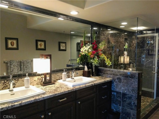 bathroom featuring a stall shower, a sink, recessed lighting, and double vanity