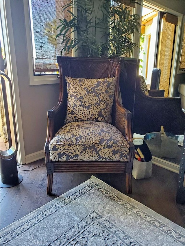 sitting room with baseboards, hardwood / wood-style flooring, and a healthy amount of sunlight