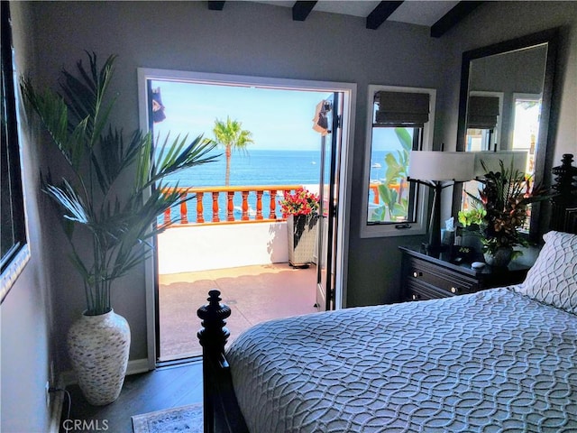 bedroom with a water view and wood finished floors