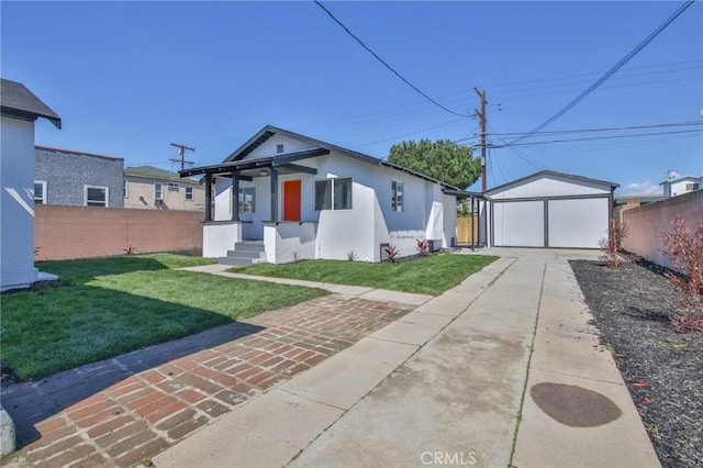 bungalow-style house featuring an outbuilding, fence, a detached garage, and a front lawn