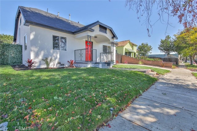 view of front of house featuring a front lawn and stucco siding