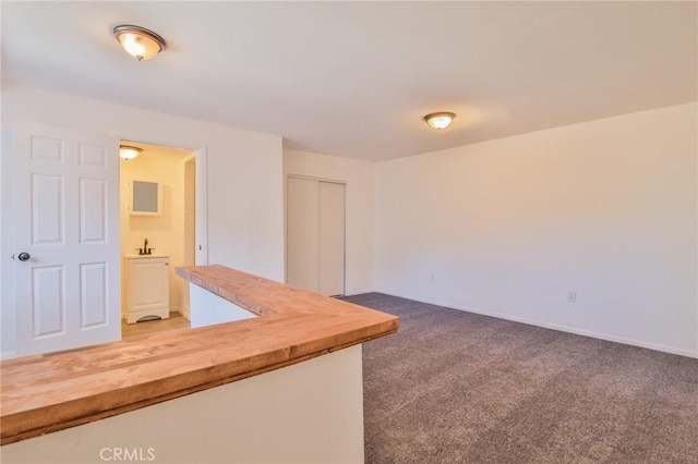 empty room with carpet and baseboards