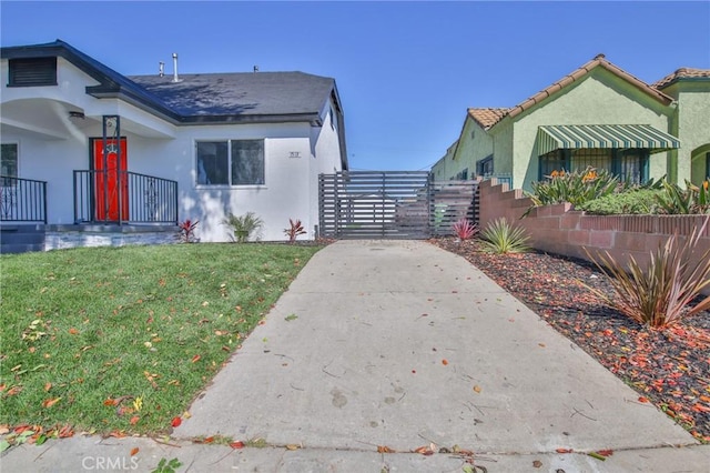 view of property exterior featuring a lawn, fence, and stucco siding