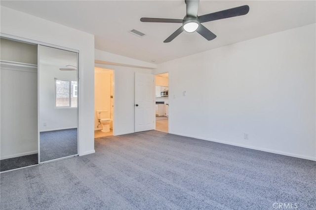 unfurnished bedroom featuring carpet floors, a closet, visible vents, a ceiling fan, and baseboards