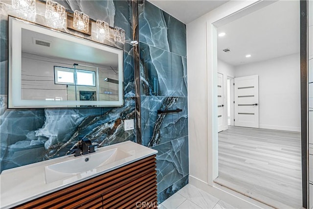 bathroom featuring visible vents, vanity, and baseboards