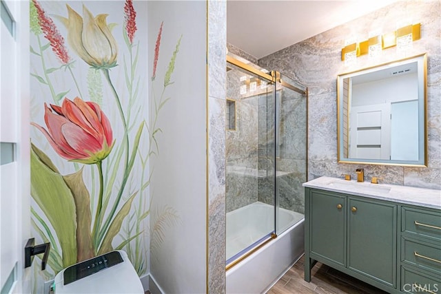 full bath featuring tile walls, shower / bath combination with glass door, vanity, and wood finished floors