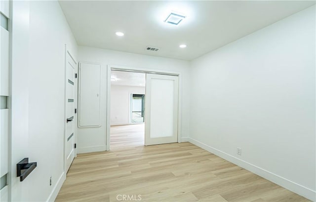 unfurnished room featuring light wood-style flooring, recessed lighting, visible vents, and baseboards