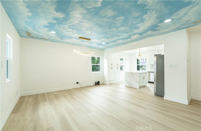 unfurnished room with light wood-style flooring and baseboards