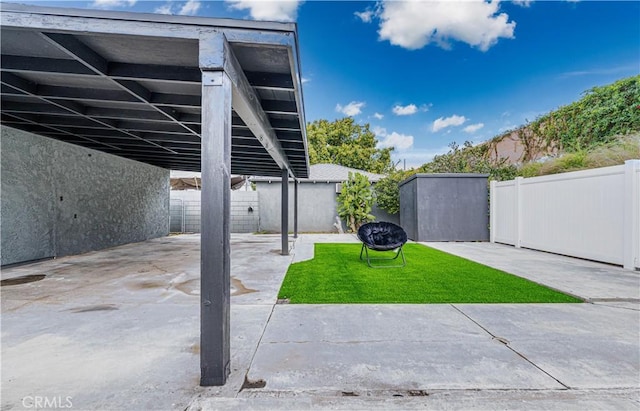 view of yard with an outbuilding, a fenced backyard, a patio, and a storage unit