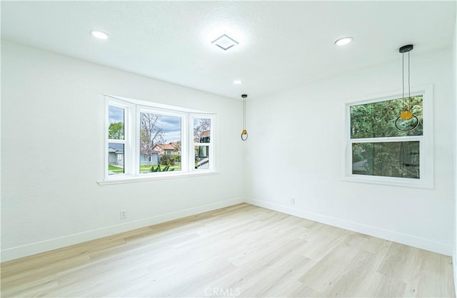 empty room with light wood-style floors, baseboards, and recessed lighting