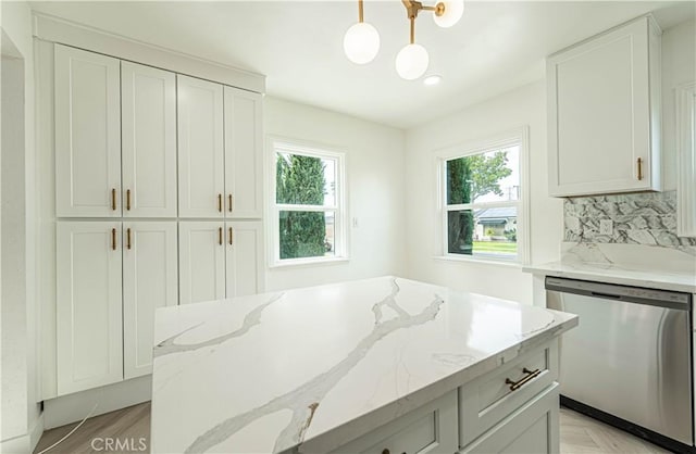 kitchen with light stone counters, a wealth of natural light, backsplash, and stainless steel dishwasher