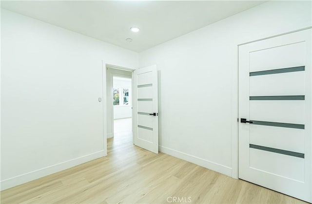 spare room with recessed lighting, wood finished floors, and baseboards