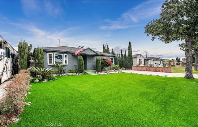 view of front of home with fence, a front lawn, and stucco siding