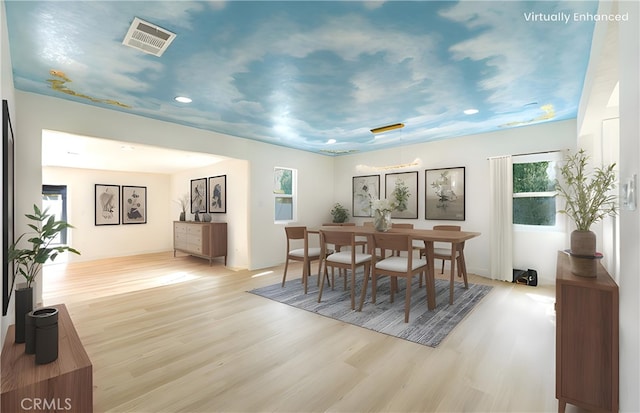 dining area with light wood-style flooring and visible vents