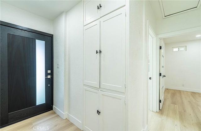 foyer with light wood finished floors and baseboards