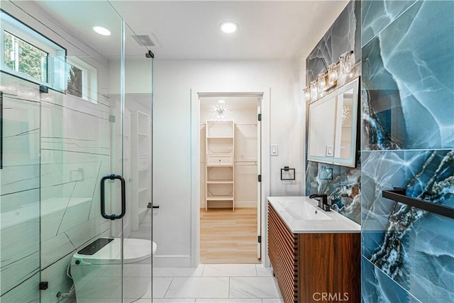 full bath featuring visible vents, a walk in closet, vanity, a shower stall, and recessed lighting