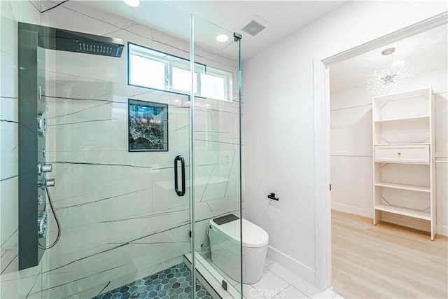 full bath featuring visible vents, toilet, a shower stall, wood finished floors, and baseboards