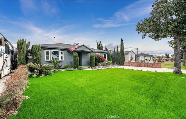 view of front of property with a front yard, fence, and stucco siding