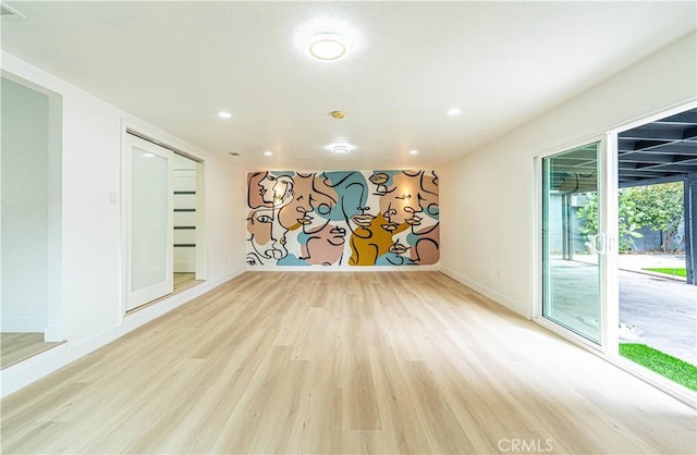 empty room with recessed lighting, light wood-style flooring, and baseboards