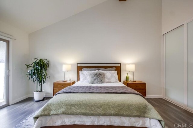 bedroom featuring access to exterior, high vaulted ceiling, baseboards, and wood finished floors