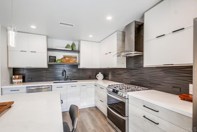 kitchen with open shelves, wall chimney range hood, appliances with stainless steel finishes, modern cabinets, and a sink