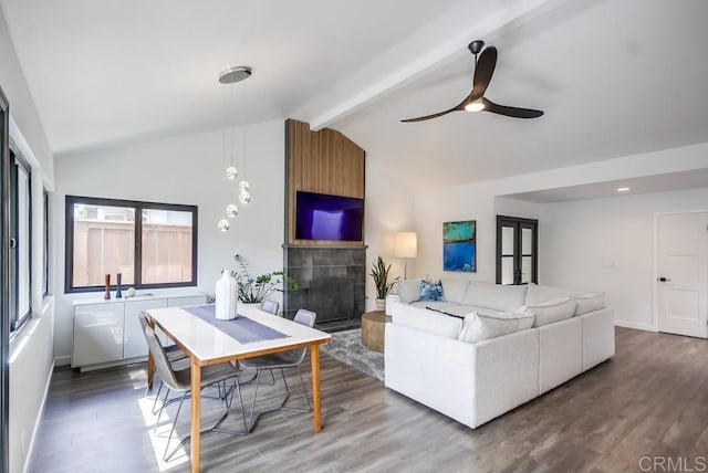 living room with lofted ceiling with beams, baseboards, wood finished floors, and ceiling fan