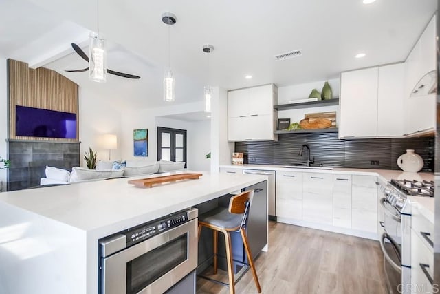 kitchen with open shelves, a sink, appliances with stainless steel finishes, white cabinetry, and modern cabinets