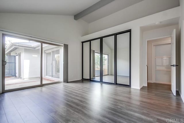 unfurnished room featuring baseboards, wood finished floors, and vaulted ceiling with beams