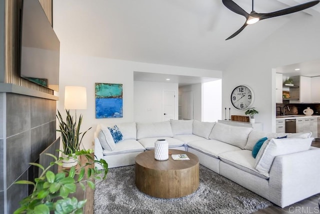 living area featuring vaulted ceiling and a ceiling fan