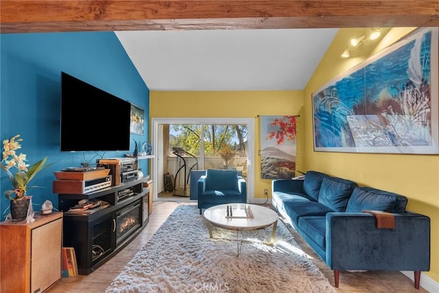 living room featuring vaulted ceiling with beams, light wood-style floors, and baseboards