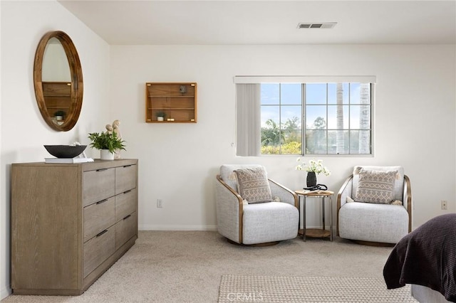 living area with visible vents, baseboards, and light colored carpet