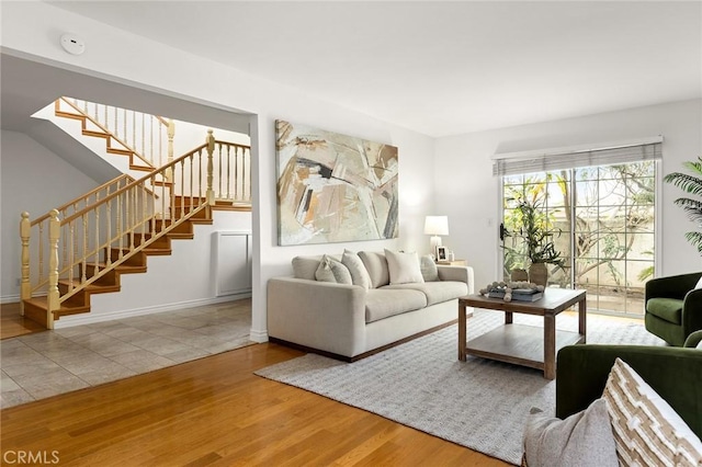 living room featuring stairs, wood finished floors, and baseboards