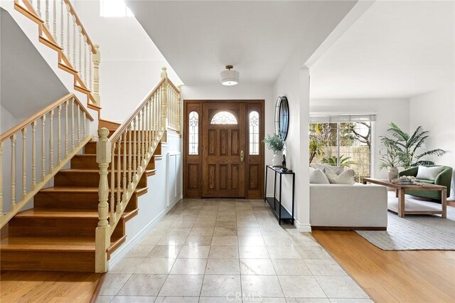 foyer entrance featuring stairway and wood finished floors