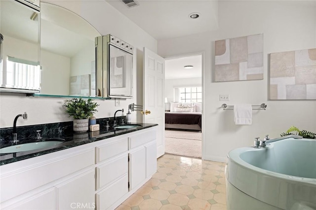 ensuite bathroom with a garden tub, visible vents, ensuite bathroom, and a sink